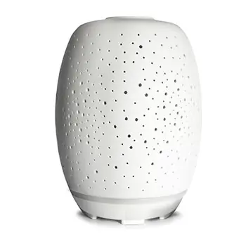 White aroma diffuser with a perforated dotted surface and a rounded, cylindrical shape on a subtle base.