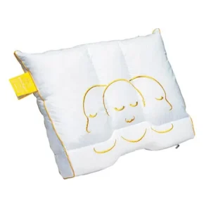 White decorative pillow featuring three yellow-outlined sleeping faces; yellow trim and tag on the side.